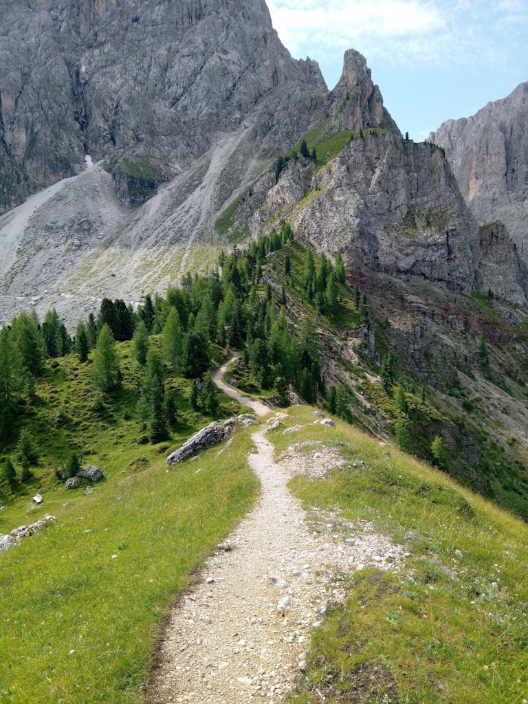 A picturesque hiking path winds through the green mountains of the Dolomites, Veneto, Italy.